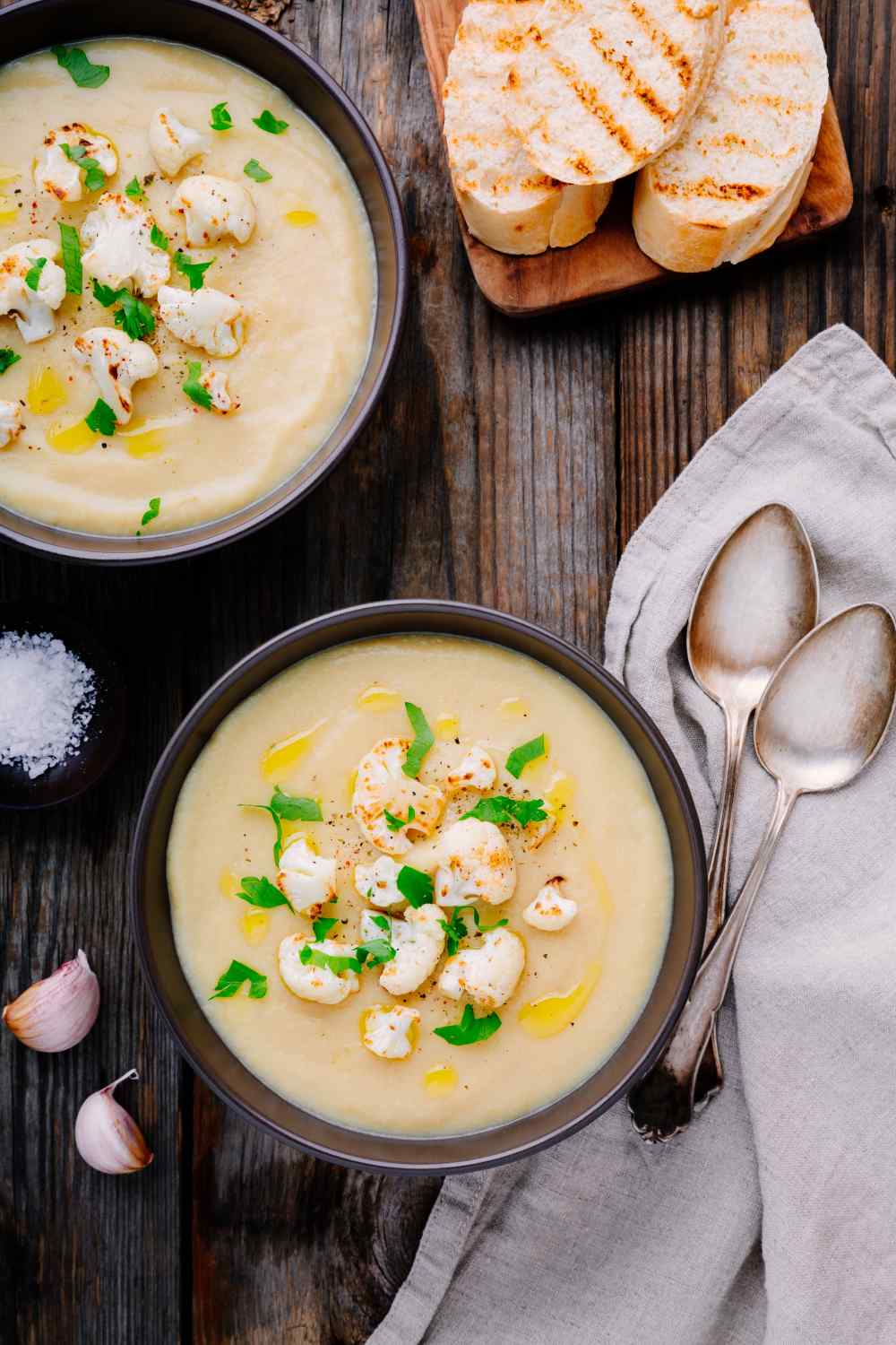 zwei Schüsseln mit Kartoffelsuppe mit Blumenkohl und geröstetem Brot