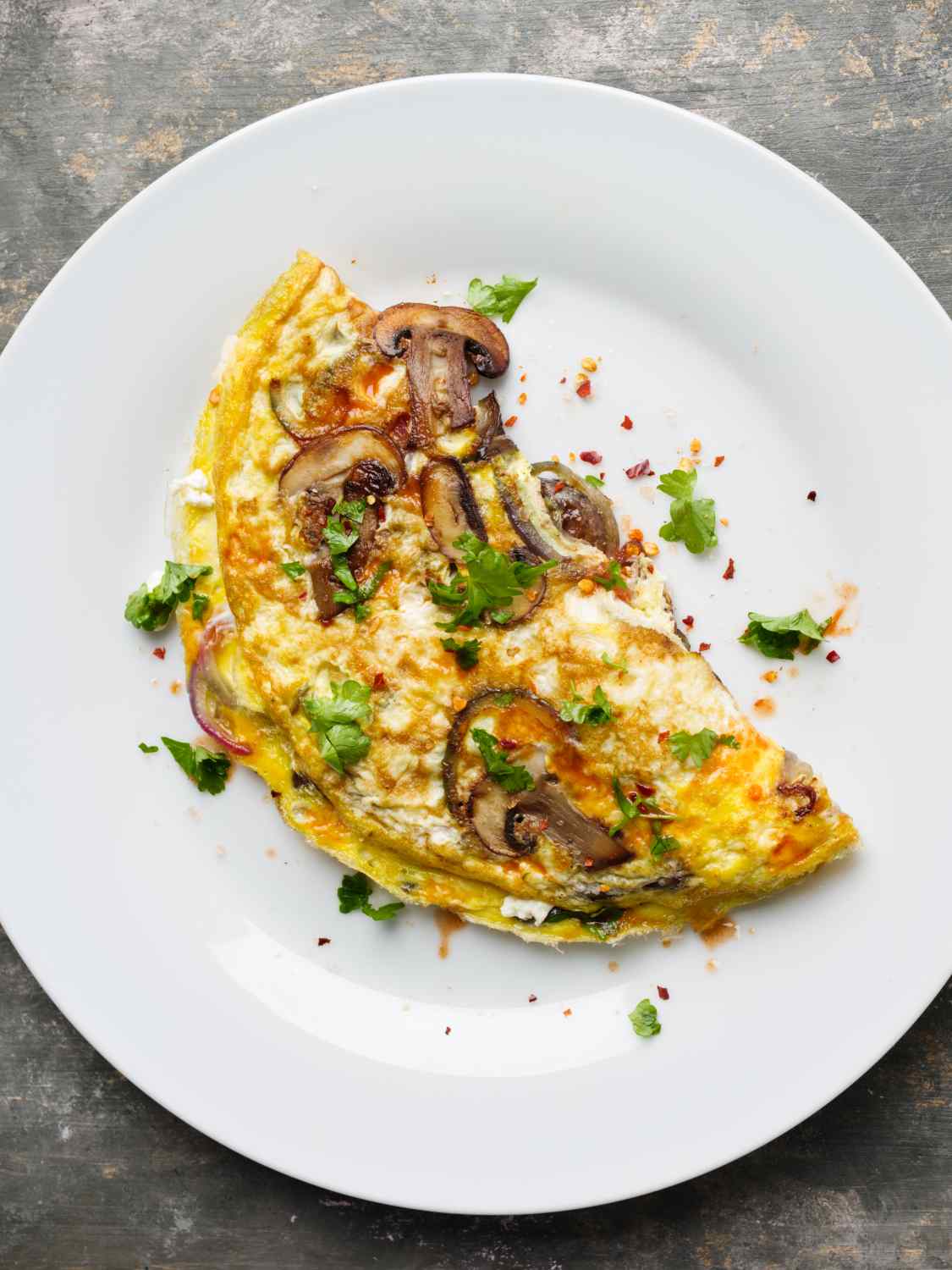 halbes Omelette mit Pettersilie, Champignons und roten Zwiebeln