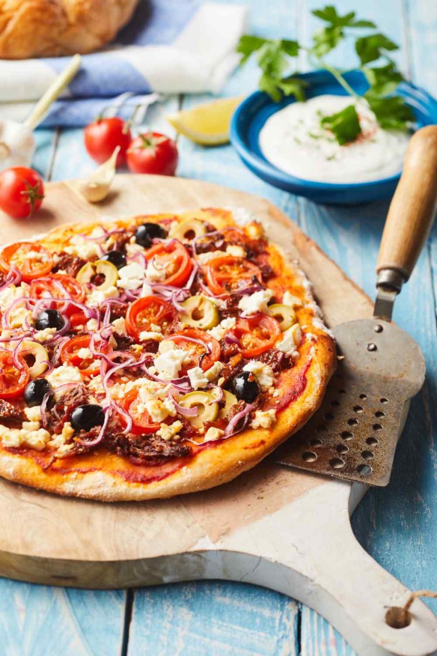 Fladenbrot belegt wie eine Pizza mit Toamten, Oliven und Käse