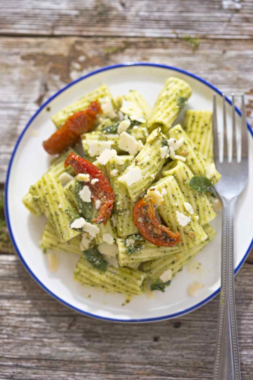 Nudeln, getrocknete Tomate, Käse und Kräuter auf Teller