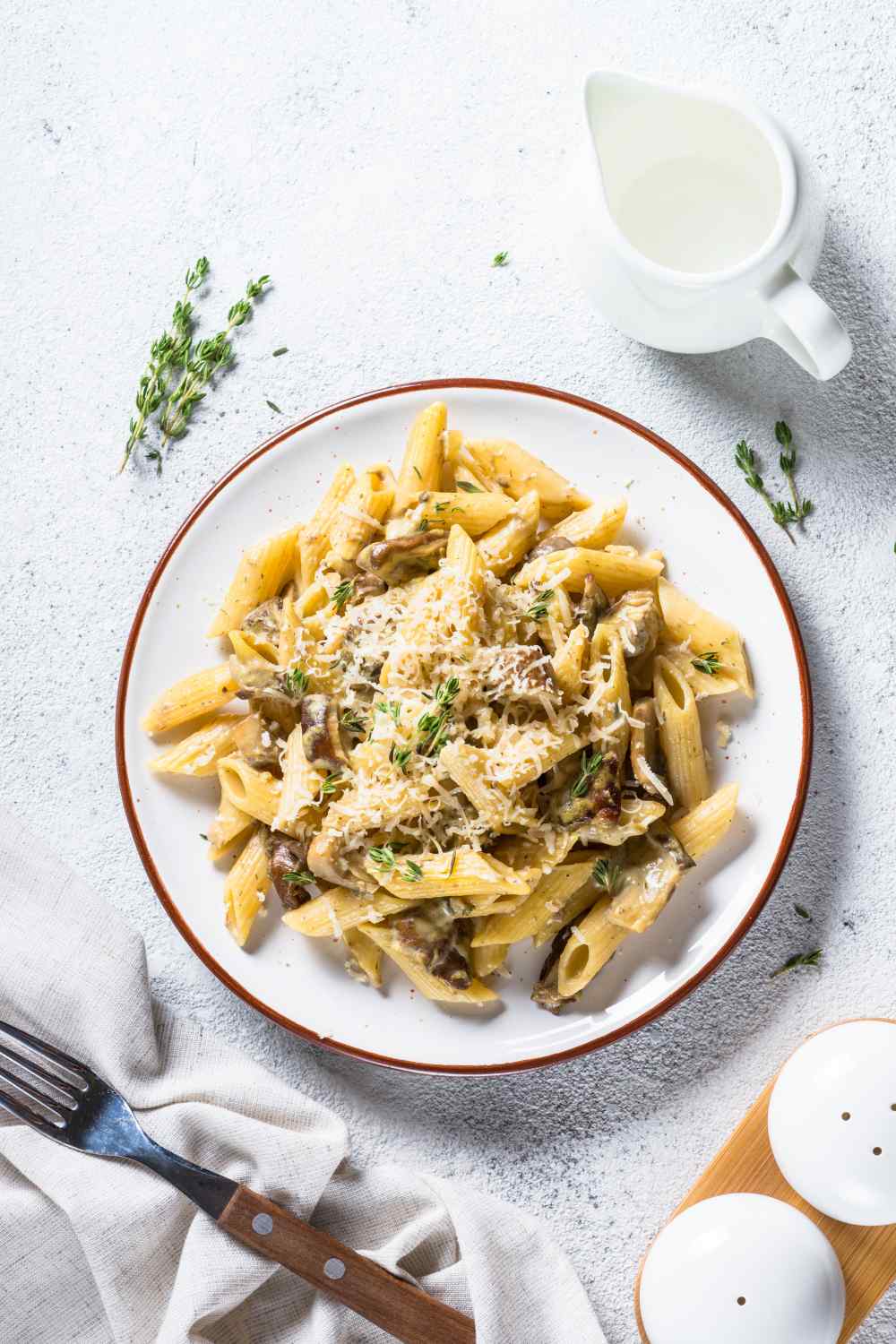 Nudeln mit Champignons und Reibekäse auf einem Teller