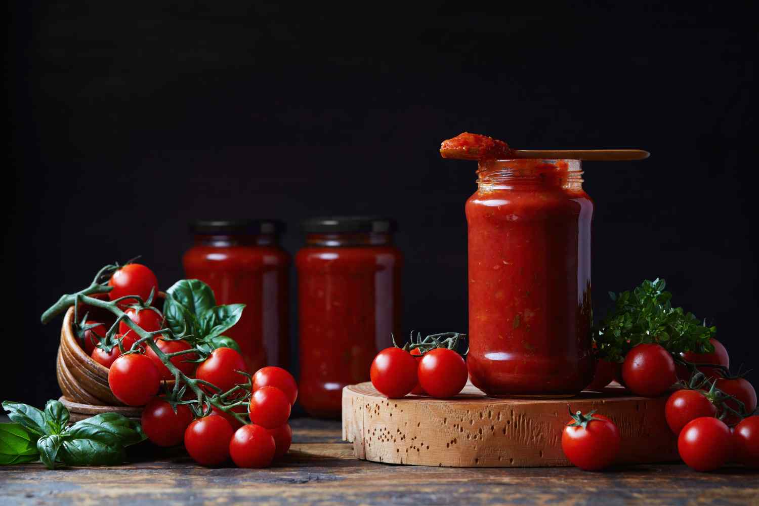 Tomatensoße in Gläsern und frische Tomaten