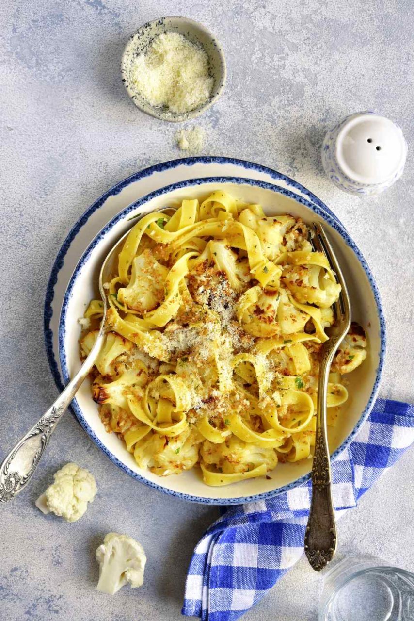 Schüssel gefüllt mit Bandnudeln, Blumenkohlstücken und Käse