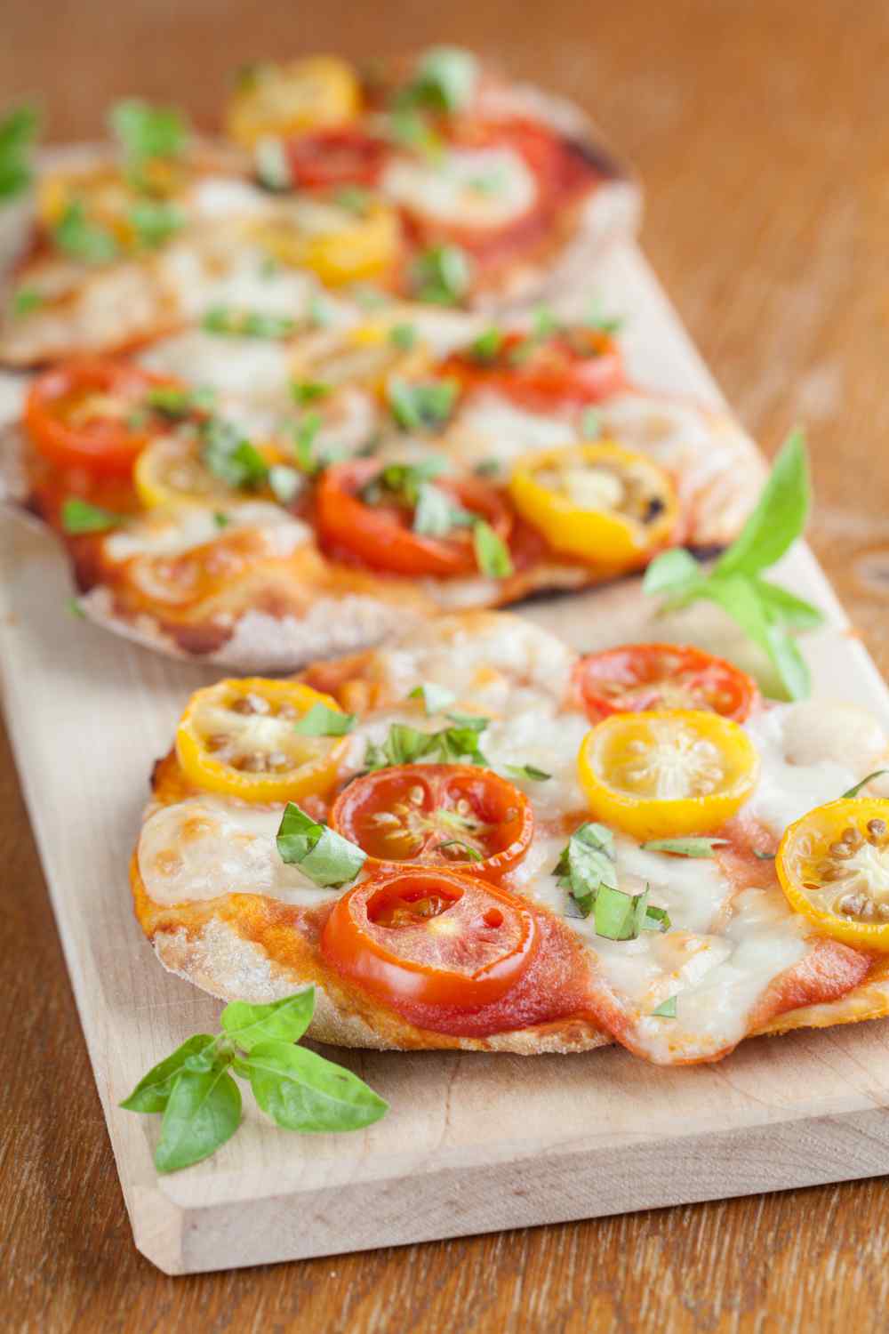kleine Pizza mit gelben und roten Tomatenscheiben