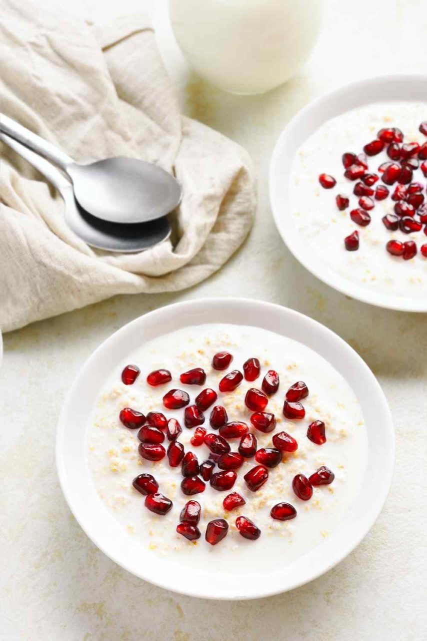 Teller mit Porridge und roten Grantapfelkernen