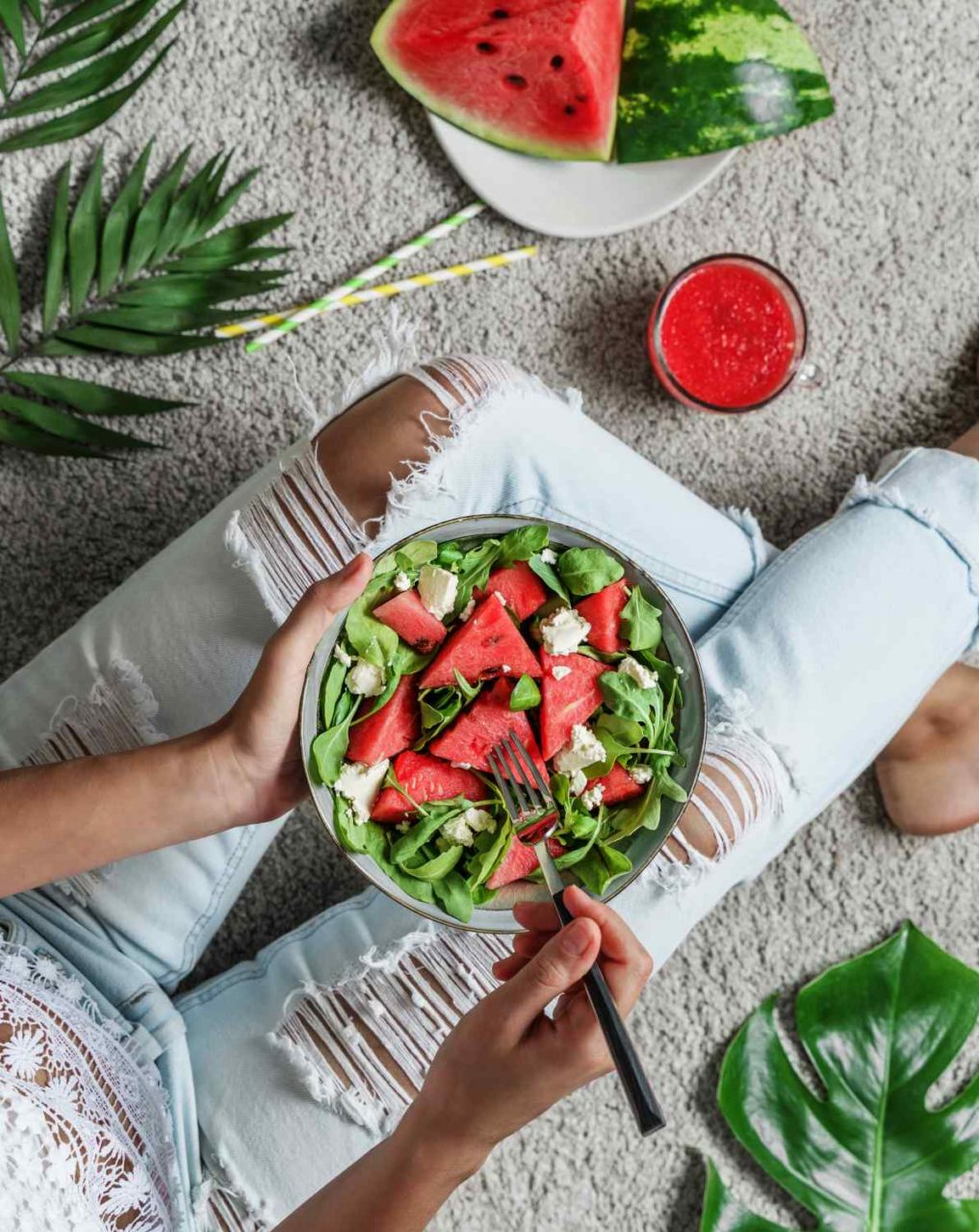 Frau isst Salat mit Wassermelone